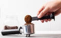 A man pours coffee from a measuring spoon into a coffee maker's horn on a white background. Copy space for text Royalty Free Stock Photo
