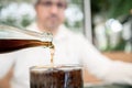 Man pours drink cola into a glass