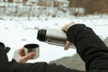 A man pours a drink from a thermos into the lid outdoor Royalty Free Stock Photo