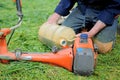 man pours fuel lawn mower