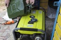 A man pours gasoline into a generator