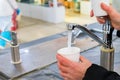 Man pours mineral water in glass in pump-room Royalty Free Stock Photo