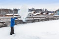 The man pours out the boiling water of a ladle on the street, a frost minus 25 degrees.