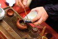 Man pours tealeafs into teapot