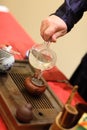 Man pours water into teapot on tea tray