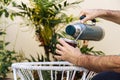 A man pours water from a thermos into a mate in the backyard