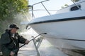 Man power washing boat hull Royalty Free Stock Photo