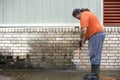 Man powerwashing mold of wall - DIY