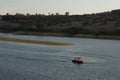 Man practices boat turns on the water with waves at sunset next to the mountain sails on the lake Royalty Free Stock Photo