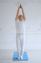 Man practicing advanced yoga against a white background Royalty Free Stock Photo