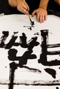 A man practicing Japanese calligraphy