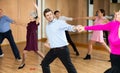 Man practicing jitterbug with female partner in dance studio