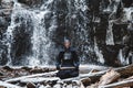 Man practicing kendo with bamboo sword on waterfall background. Place for text or advertising