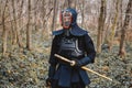 Man practicing kendo with shinai bamboo sword on forest background. Place for text or advertising