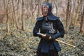 Man practicing kendo with shinai bamboo sword on forest background. Place for text or advertising