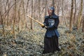 Man practicing kendo with shinai bamboo sword on forest background. Place for text or advertising