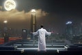 Man practicing qigong showing energy of tai chi outdoors, evening city lights and skyscrapers background