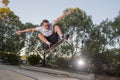 Man practicing radical skate board jumping and enjoying tricks and stunts in concrete half pipe skating track in sport and healthy Royalty Free Stock Photo