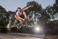 Man practicing radical skate board jumping and enjoying tricks and stunts in concrete half pipe skating track in sport and healthy