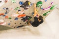 Man practicing rock climbing on artificial wall indoors. Active lifestyle and bouldering concept Royalty Free Stock Photo