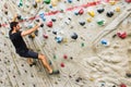 Man practicing rock climbing on artificial wall indoors. Active lifestyle and bouldering concept Royalty Free Stock Photo