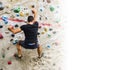 Man practicing rock climbing on artificial wall indoors. Active lifestyle and bouldering concept with copy space Royalty Free Stock Photo