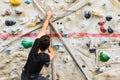 Man practicing rock climbing on artificial wall indoors. Active lifestyle and bouldering concept Royalty Free Stock Photo