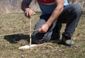 Man using sticks and friction method to start a fire