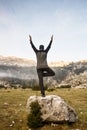 Man practicing yoga, performing a tree pose