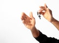 Man praying with arms outstretched and holding a cross Royalty Free Stock Photo