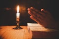 Man praying on the Bible in the light candles selective focus Royalty Free Stock Photo