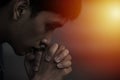 A man praying and close your eyes in praying. Prayer to pray. A young man is holding palms by his lips, whispering a prayer, and Royalty Free Stock Photo