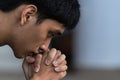 A man praying and close your eyes in praying. Prayer to pray. A young man is holding palms by his lips, whispering a prayer, and Royalty Free Stock Photo