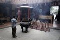 Man praying in incense smoke filled temple in Ho Chi Minh City Royalty Free Stock Photo