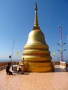 A man praying near Golden stupa in a Buddhist Temple in Thailand Royalty Free Stock Photo