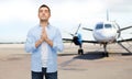 Man praying over airplane on runway background Royalty Free Stock Photo