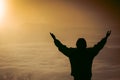 Man praying at sunset mountains raised hands Travel Lifestyle spiritual relaxation emotional concept, Freedom and travel adventure Royalty Free Stock Photo