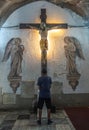 Man prays in front of Jesus on the Cross at San Augustin church, Manila Philippines Royalty Free Stock Photo