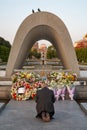 Man prays in front of the Memorial Cenotaph for the A-bomb Victims in Peace Park. Hiroshima. Japan