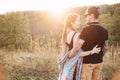 Man and pregnant woman hugging holding hands on the background of wild nature, autumn. love story Royalty Free Stock Photo