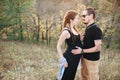 Man and pregnant woman hugging holding hands on the background of wild nature, autumn. love story Royalty Free Stock Photo