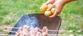 Man prepares barbecue meat with potatoes Royalty Free Stock Photo