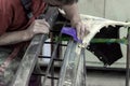 A man prepares a car body element for painting after an accident