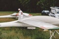 Man prepares and checks gliders parked in the field.