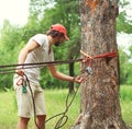 Man prepares a equipment fixes the carabiner on the rope tying for mountain climbing or slacklining in the park Royalty Free Stock Photo