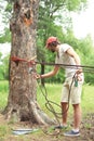 Man prepares the equipment fixes secures the rope to the tree Royalty Free Stock Photo