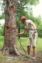 Man prepares the equipment fixes secures the rope to the tree