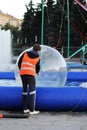 man prepares an inflatable ball for water zorbing in the pool. Royalty Free Stock Photo