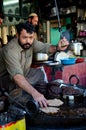 Man prepares Pakistani chapli kebab meat dish on skillet Gilgit Pakistan
