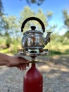 A man prepares tea on a portable gas stove outdoors. Preparing breakfast for a picnic during a hike. Travel camping Royalty Free Stock Photo